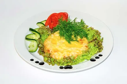 A salad with egg and tomatoes on a white plate.